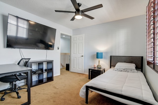 bedroom with ceiling fan, light carpet, and a textured ceiling