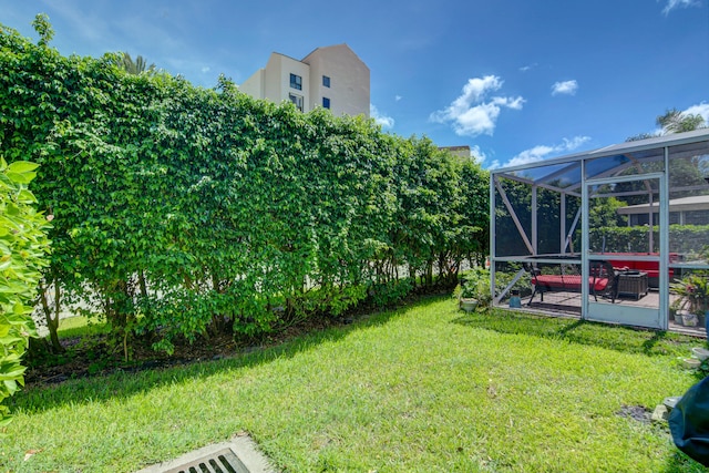 view of yard featuring a patio area and glass enclosure