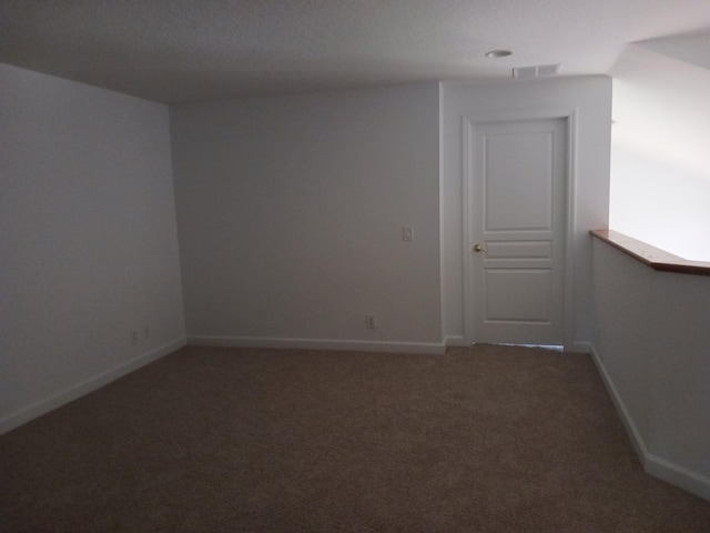 spare room with dark colored carpet