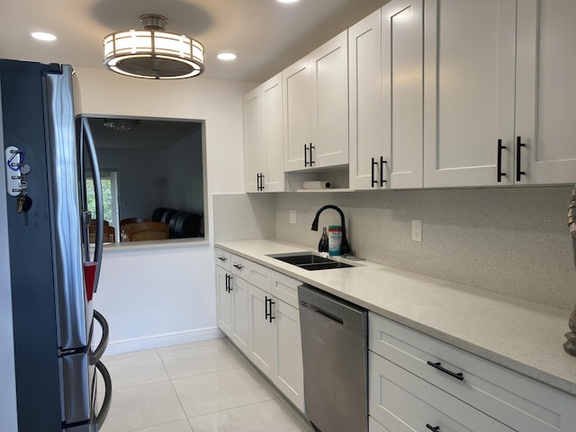 kitchen with decorative backsplash, white cabinetry, sink, and stainless steel appliances