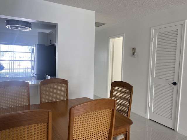 dining room with light tile patterned floors and a textured ceiling