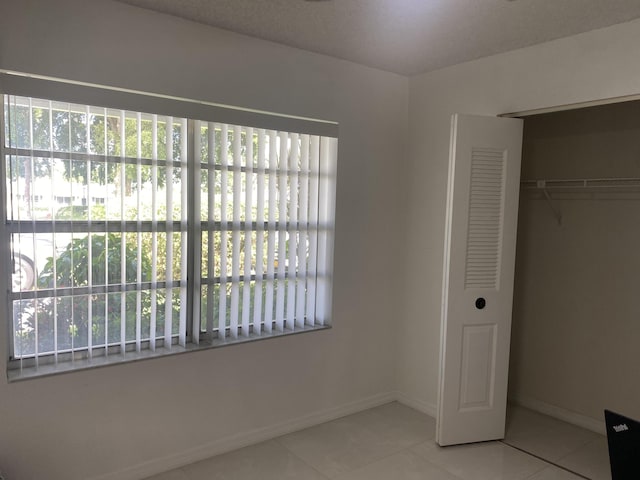 unfurnished bedroom featuring a closet and light tile patterned floors