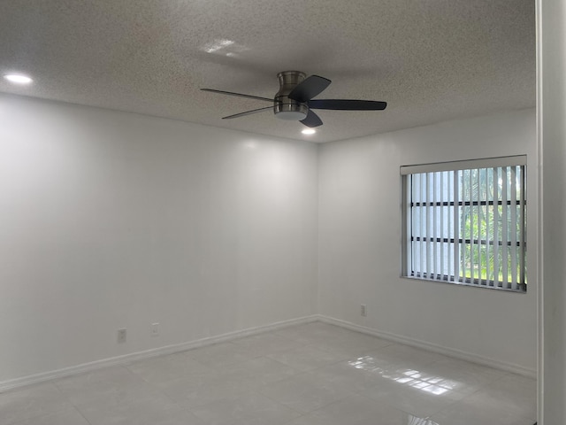 empty room with ceiling fan and a textured ceiling