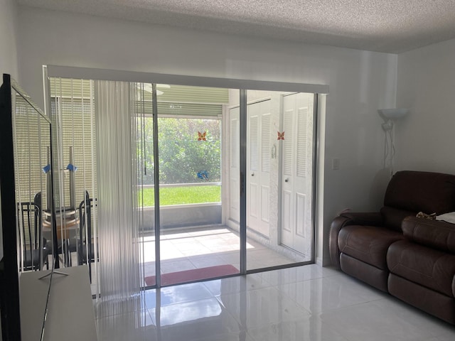 entryway with light tile patterned floors and a textured ceiling