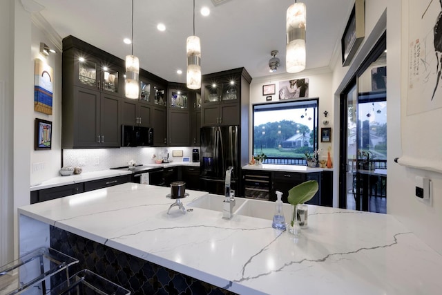 kitchen featuring pendant lighting, crown molding, light stone countertops, a kitchen bar, and stainless steel appliances