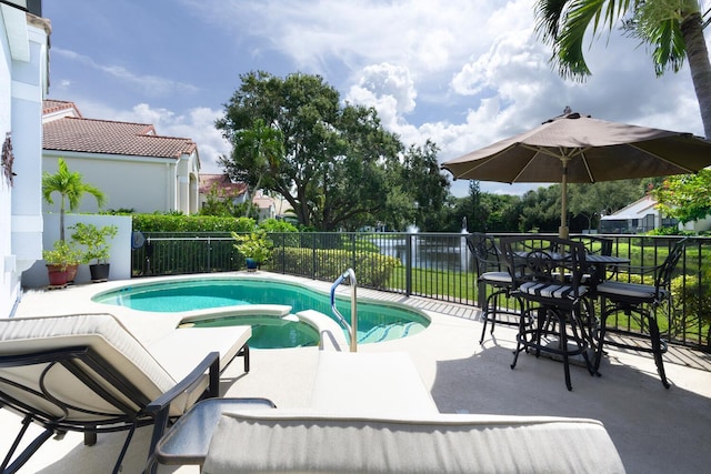 view of swimming pool featuring an in ground hot tub and a patio