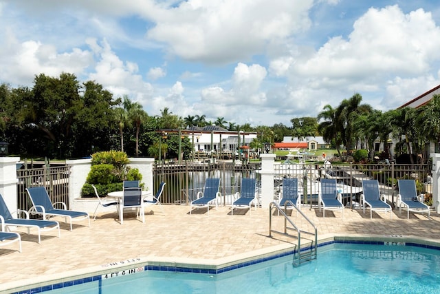 view of pool with a water view and a patio