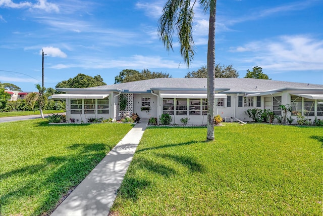 ranch-style house featuring a front lawn and a sunroom