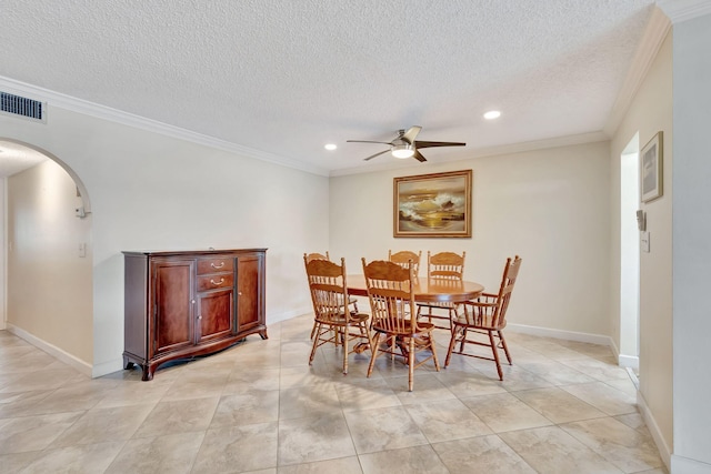 tiled dining area featuring ceiling fan, a textured ceiling, and ornamental molding