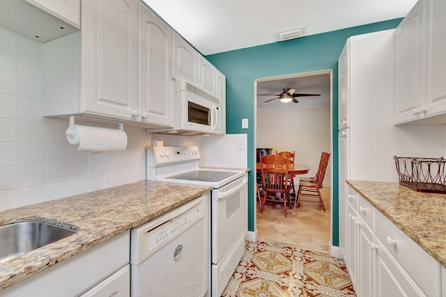 kitchen with white appliances, white cabinetry, ceiling fan, and light stone counters