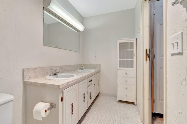 bathroom with tile patterned flooring, vanity, and toilet