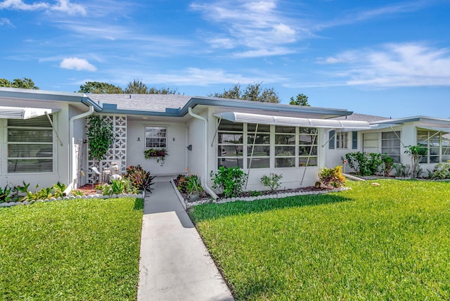 single story home featuring a front lawn