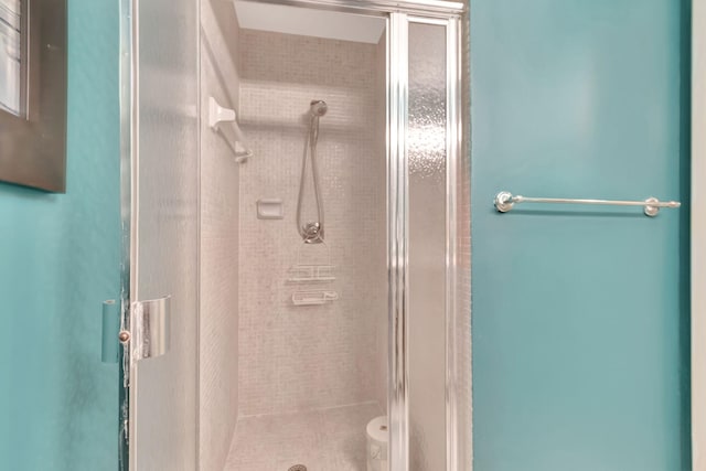 bathroom with a shower with shower door and toilet