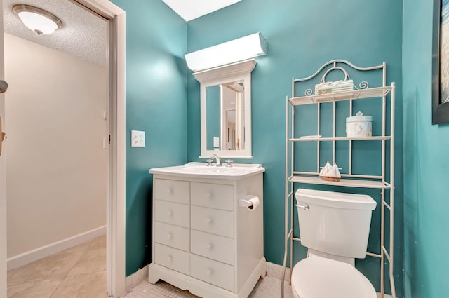 bathroom featuring a textured ceiling, tile patterned flooring, vanity, and toilet