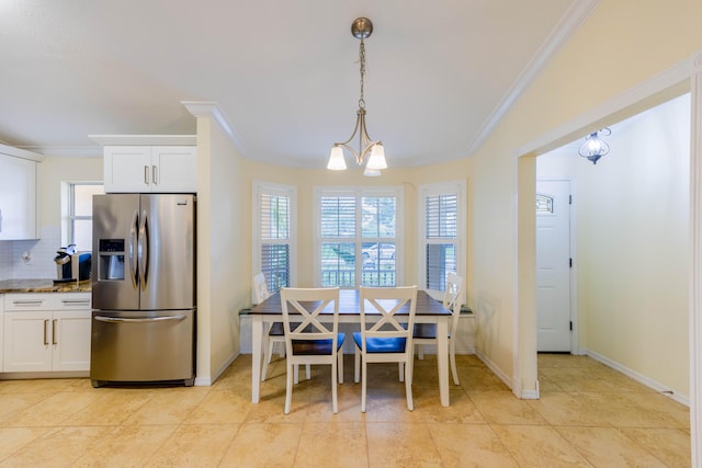 tiled dining room with a chandelier and crown molding