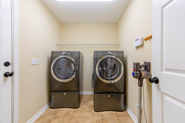 washroom featuring washing machine and dryer and light tile patterned floors