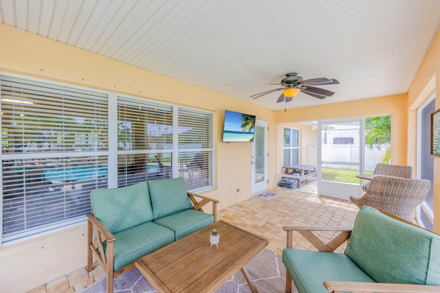 sunroom featuring ceiling fan