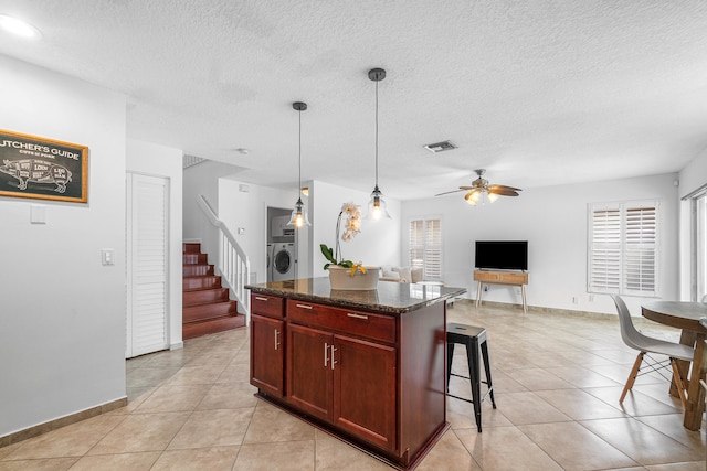 kitchen with hanging light fixtures, a kitchen island, plenty of natural light, and ceiling fan