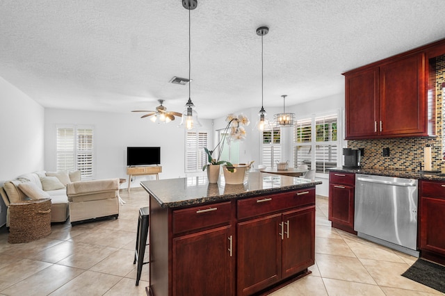 kitchen featuring ceiling fan with notable chandelier, dishwasher, pendant lighting, tasteful backsplash, and a center island