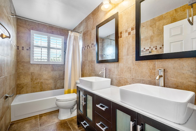 full bathroom with vanity, shower / tub combo, tile walls, toilet, and tile patterned floors