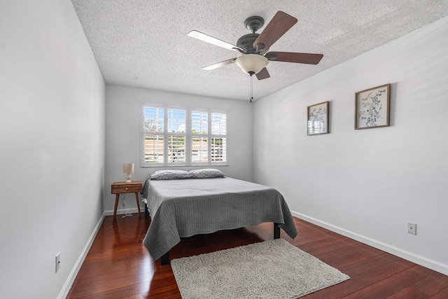 bedroom featuring dark hardwood / wood-style flooring, ceiling fan, and a textured ceiling