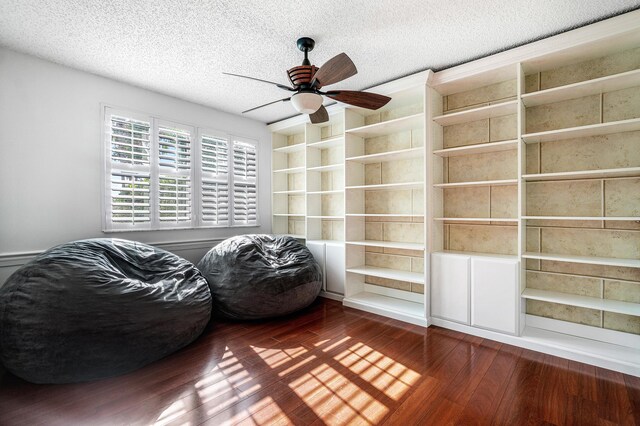 sitting room featuring a textured ceiling, ceiling fan, and dark hardwood / wood-style floors