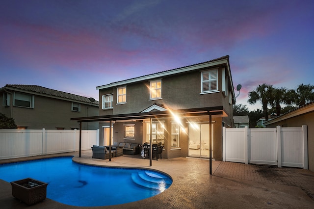 pool at dusk featuring outdoor lounge area and a patio area