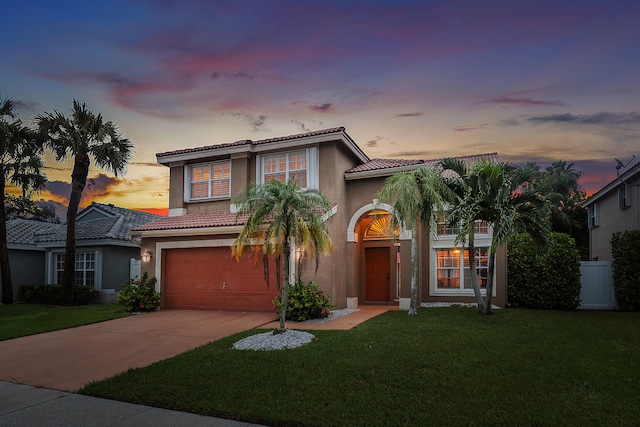 mediterranean / spanish-style home with a yard and a garage