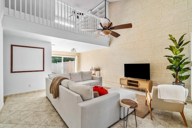 tiled living room featuring a towering ceiling and ceiling fan