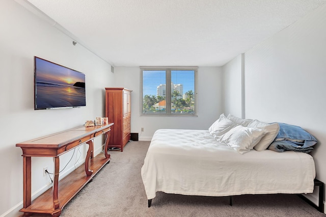 bedroom featuring a textured ceiling and carpet flooring