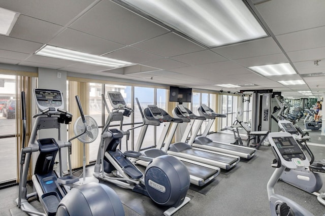 workout area featuring a drop ceiling and plenty of natural light