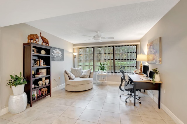 home office featuring ceiling fan, light tile patterned floors, and a textured ceiling