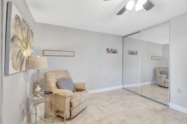 living area with light tile patterned floors and ceiling fan