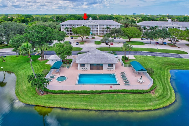 view of pool featuring a patio area, a lawn, and a water view