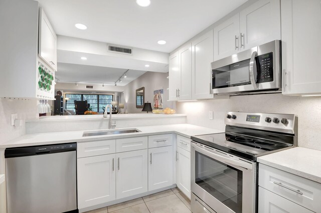 kitchen featuring stainless steel appliances, sink, white cabinets, and light tile patterned flooring