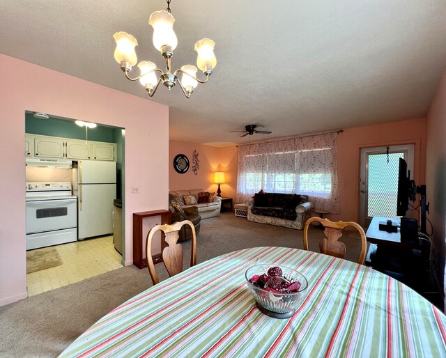 carpeted dining room featuring ceiling fan with notable chandelier and a textured ceiling