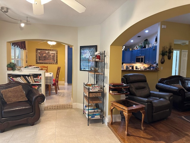 living room featuring vaulted ceiling, light hardwood / wood-style flooring, and ceiling fan