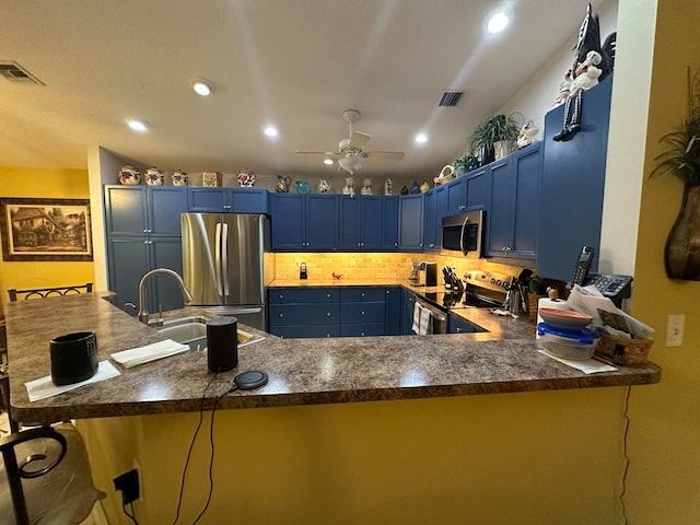 kitchen featuring kitchen peninsula, blue cabinetry, appliances with stainless steel finishes, and ceiling fan