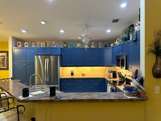 kitchen with appliances with stainless steel finishes, a kitchen bar, and blue cabinetry