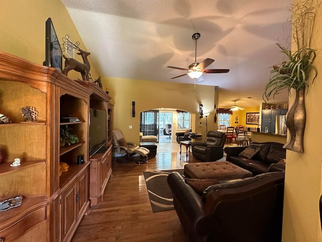 living room featuring vaulted ceiling, a textured ceiling, ceiling fan, and dark hardwood / wood-style floors