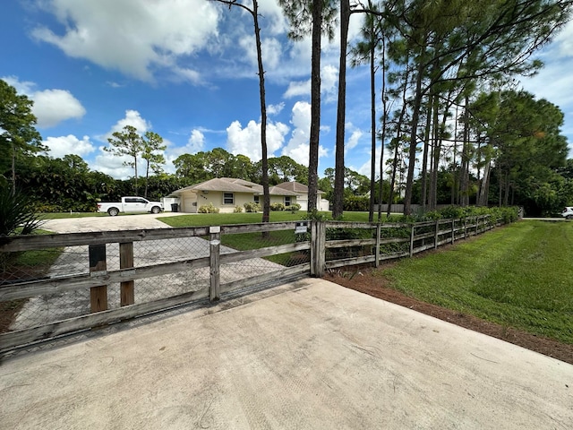 view of gate with a lawn