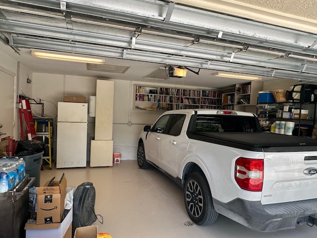 garage featuring a garage door opener and white fridge