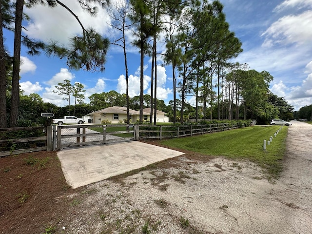 view of gate with a yard