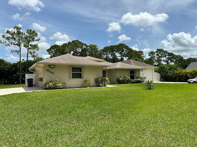 ranch-style house featuring a front lawn and a garage