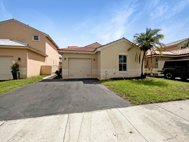 single story home featuring a front yard, an attached garage, driveway, and stucco siding