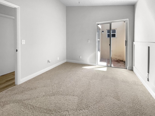 unfurnished bedroom with baseboards, carpet floors, and a textured ceiling