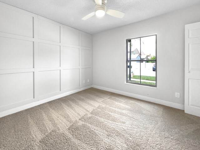 carpeted empty room with a textured ceiling and ceiling fan