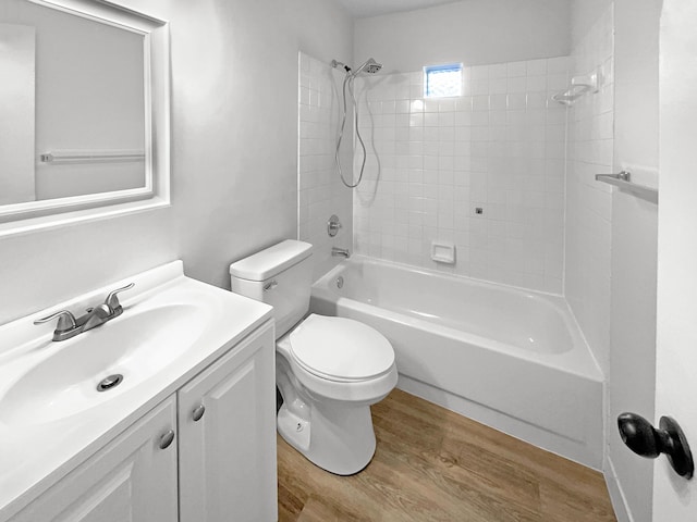 full bath with washtub / shower combination, toilet, vanity, and wood finished floors