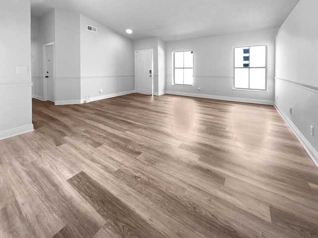 unfurnished living room with hardwood / wood-style flooring and a textured ceiling