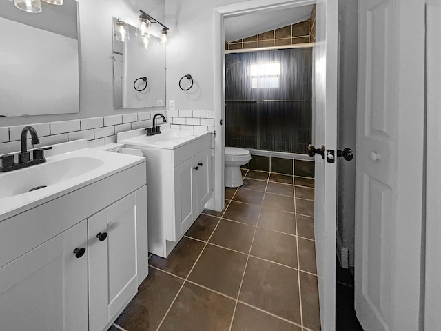 bathroom featuring tile patterned flooring, tasteful backsplash, two vanities, and a sink